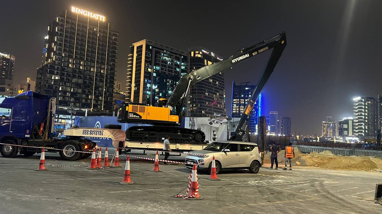 MACO Hyundai HX300SS long-boom loaded for night transit, Business Bay